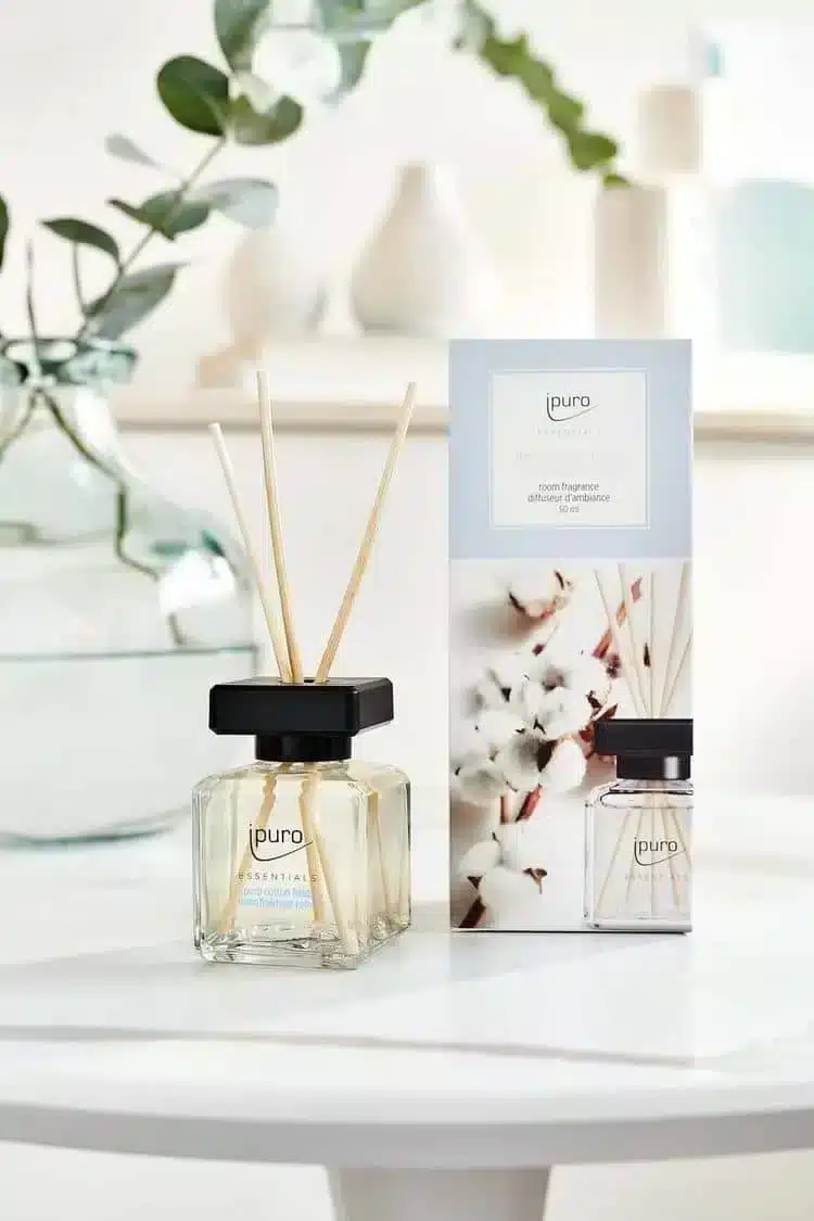ipuro Essentials Cotton Fields geurstokjes met verpakking, katoentakjes en eucalyptus op een witte tafel