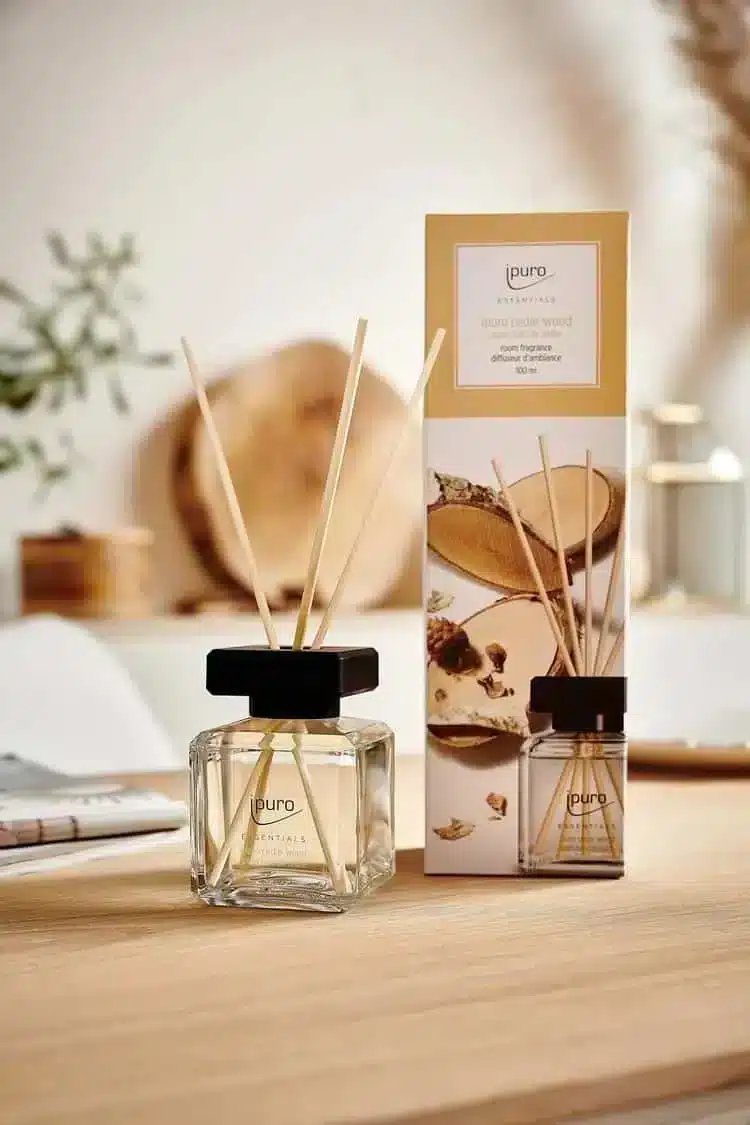 ipuro Essentials Cedar Wood geurstokjes met verpakking in warme houttinten op een lichte tafel