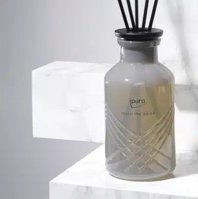 Bâtonnets parfumés ipuro Exclusive thé épicé 240ml en flacon de verre gris sur marbre blanc, gros plan